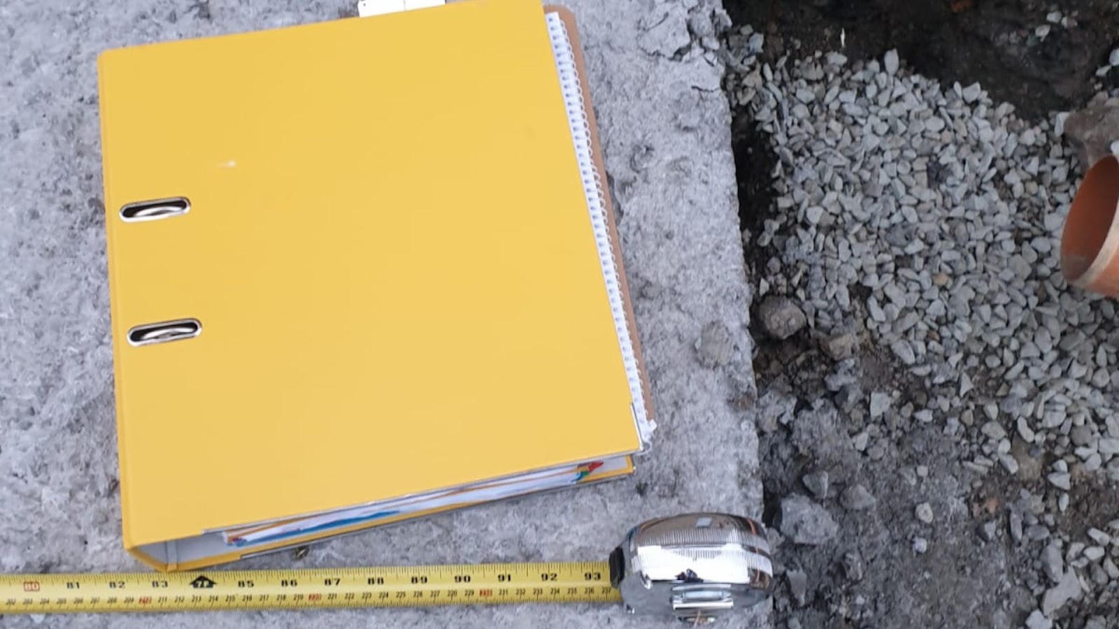 Yellow folder with a ruler next to a pipe