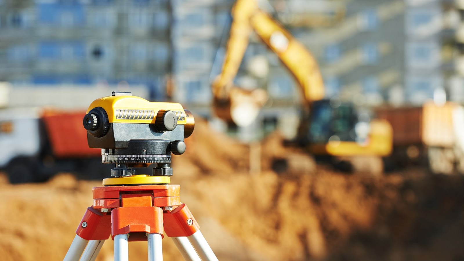 Construction site with a surveying device on top of a tripod