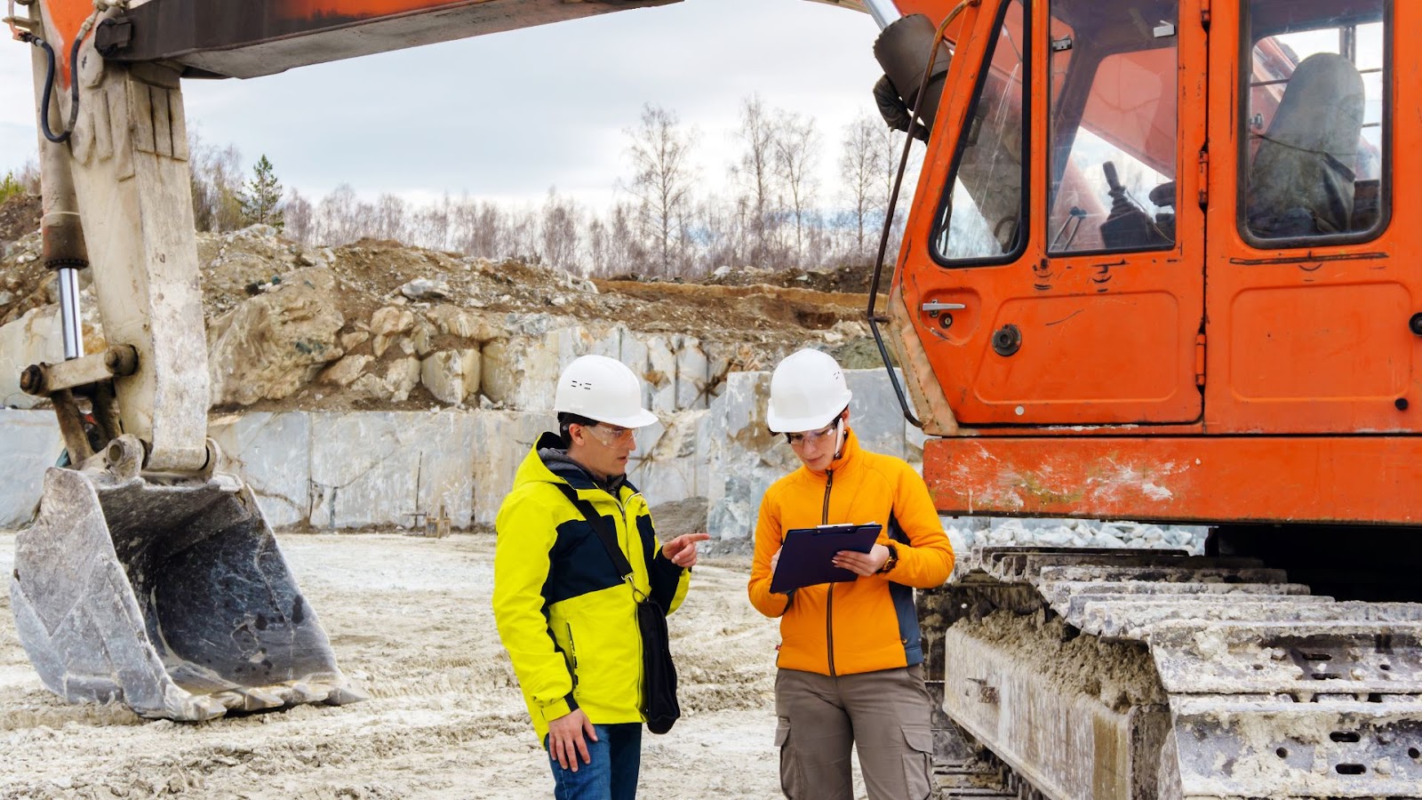 Two workers reviewing a clipboard on a construction site. 