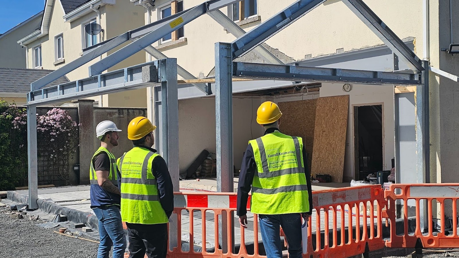 Three construction workers looking at a building site. 