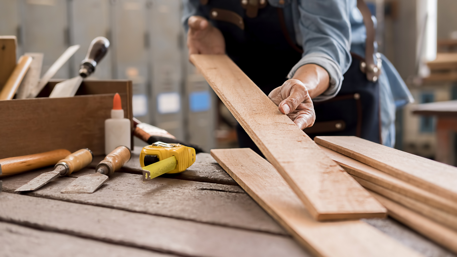 Person working on wooden table with tools. 