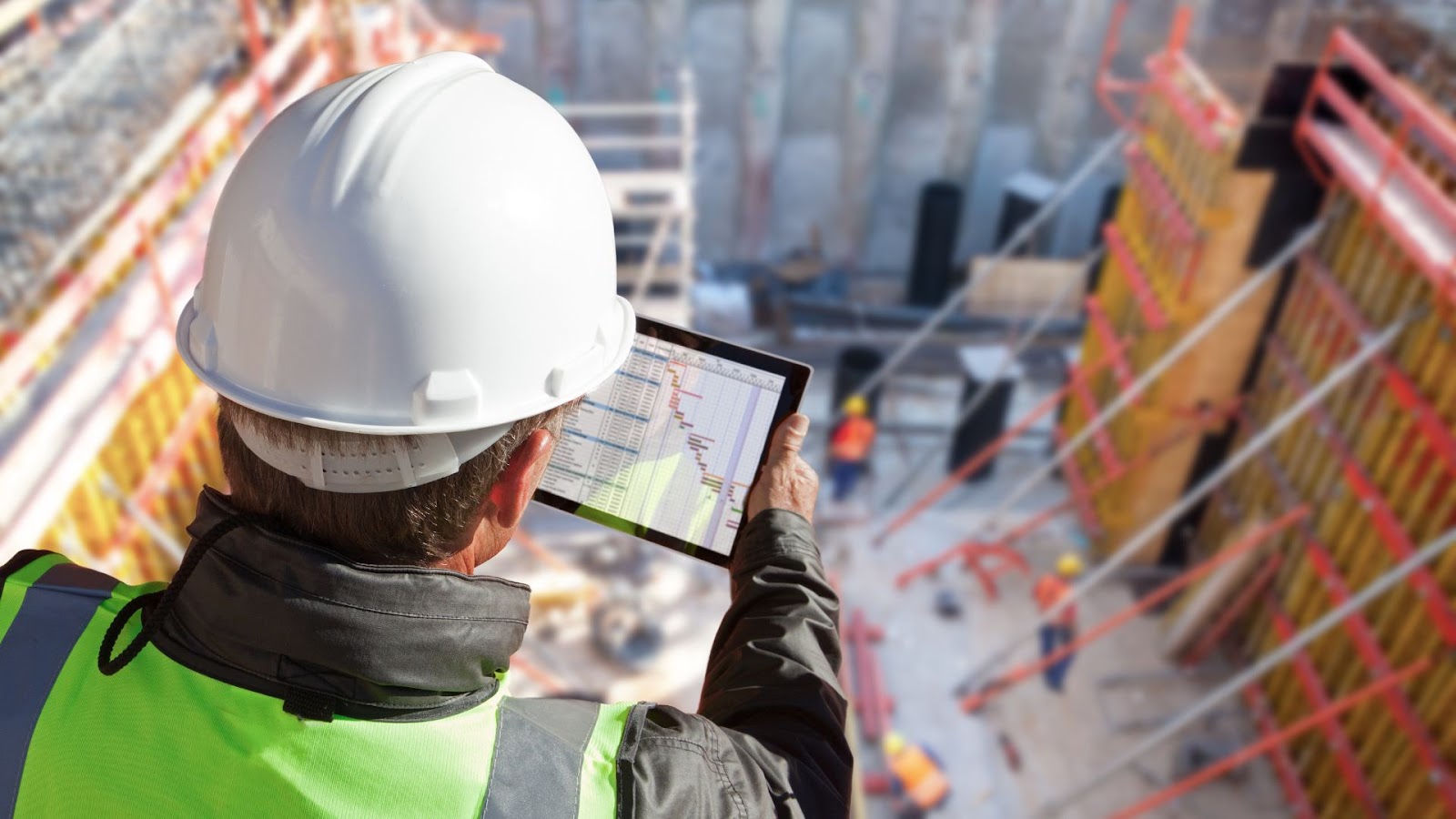 Construction worker is using a tablet on a construction site