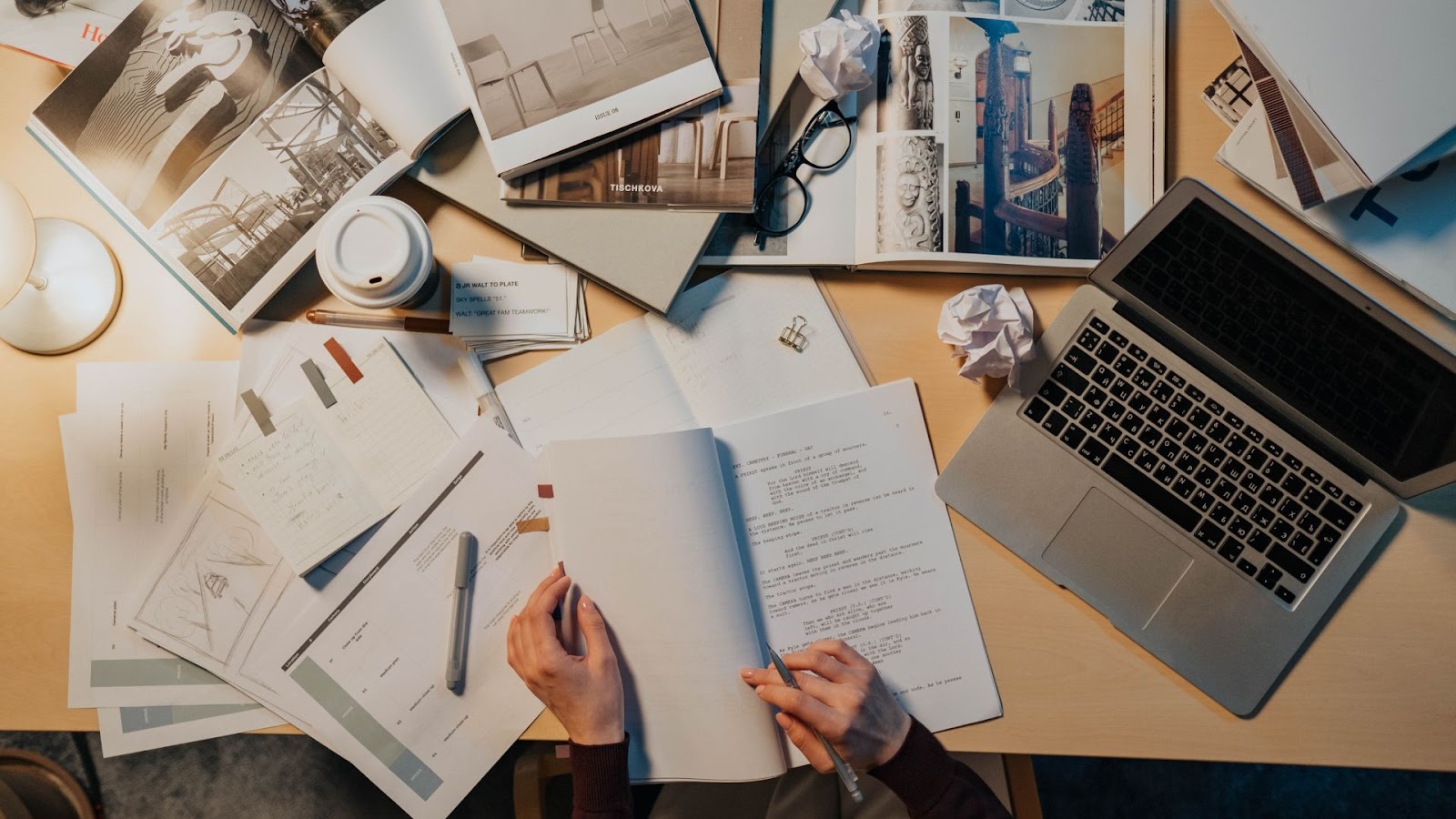 A person sitting at a desk with papers and a laptop.