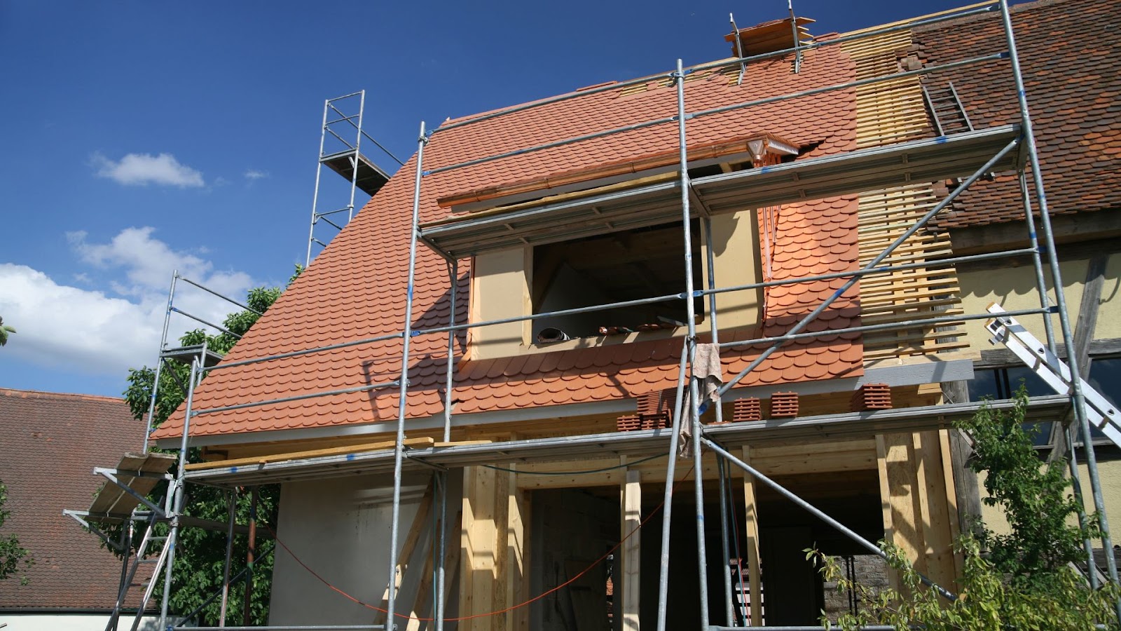 House under construction with scaffolding on the roof.