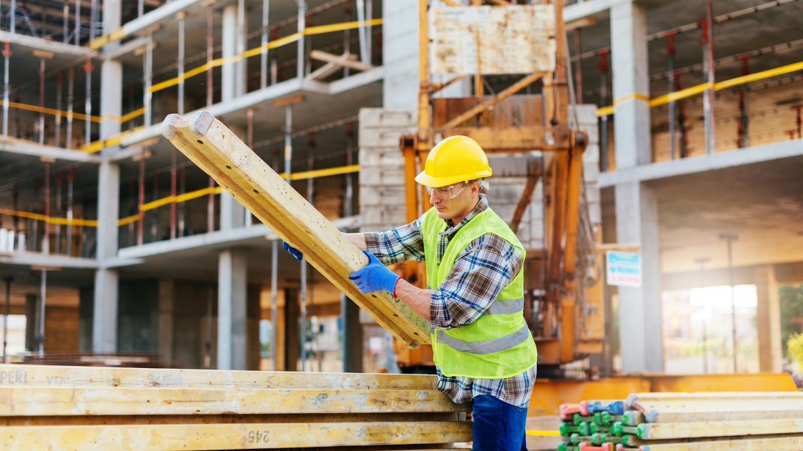 Construction worker holding a piece of wood at a construction site