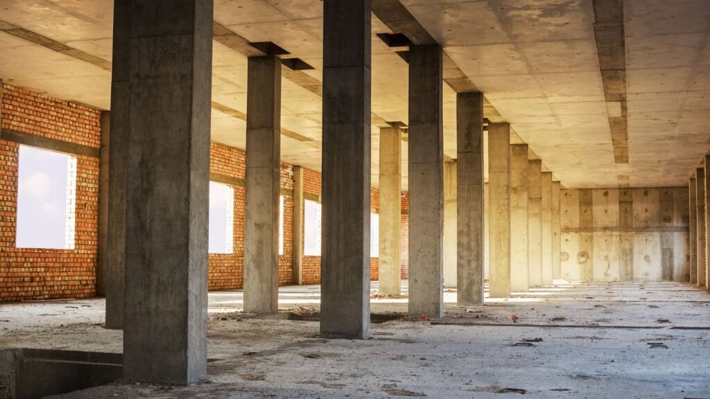 The inside of an empty building with concrete pillars