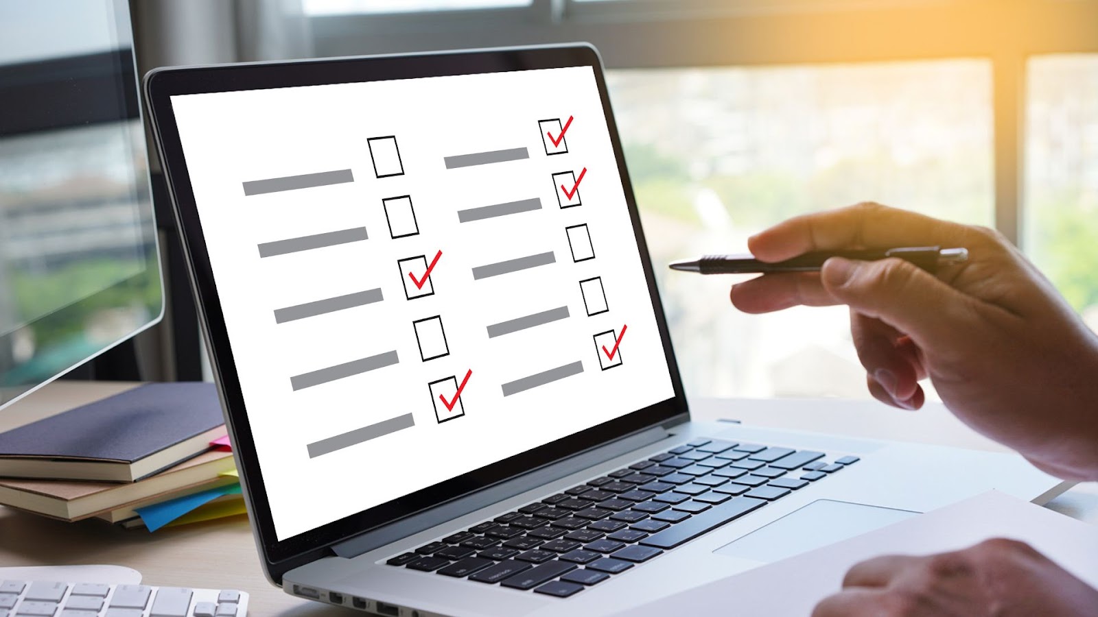 A person is working on a laptop with a checklist on the screen.