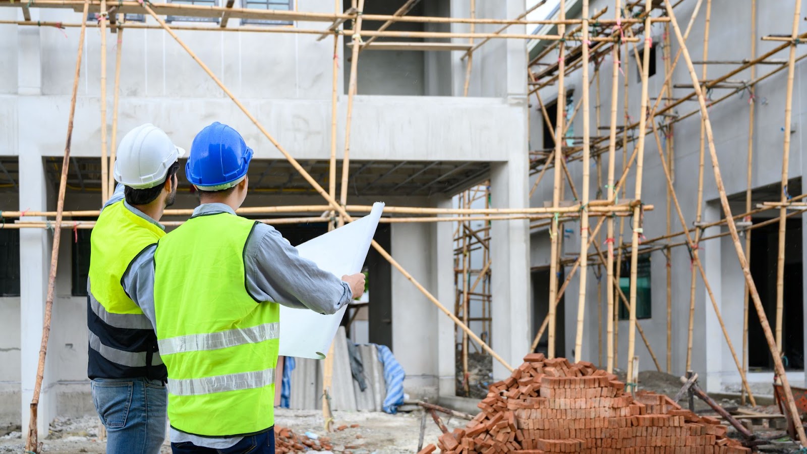 Two construction workers standing in front of a building